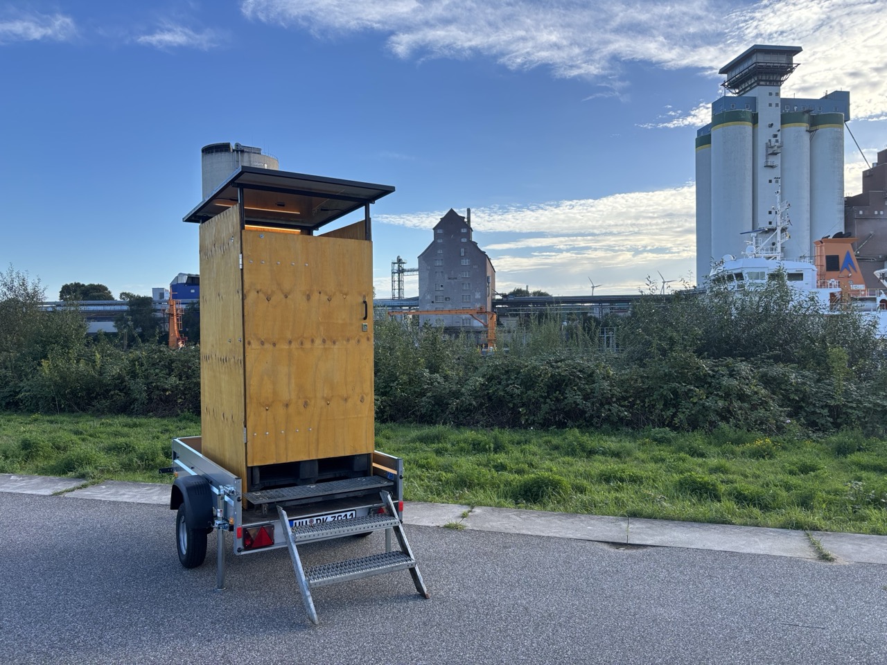 pipi-kacks Komposttoilette auf Anhänger vor Hamburger Hafenspeicher und Silos